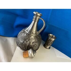 Embossed German pewter decanter and cup set with figural scenes